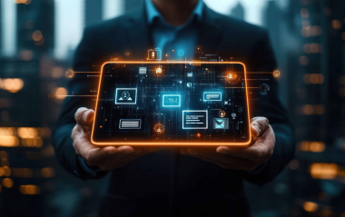 A sleek, modern office scene with a person working on a laptop in front of large screens displaying data — this image is ideal for a WALLIX Cybersecurity Operations or Threat Intelligence page, emphasizing proactive monitoring, analysis, and protection of critical systems.